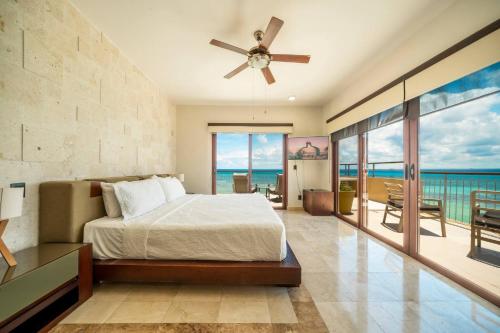 Un dormitorio con una cama y un balcón con vista al mar. en Condo Surf 408 - Beachfront Stunning Ocean View Penthouse - at El Faro condo, en Playa del Carmen