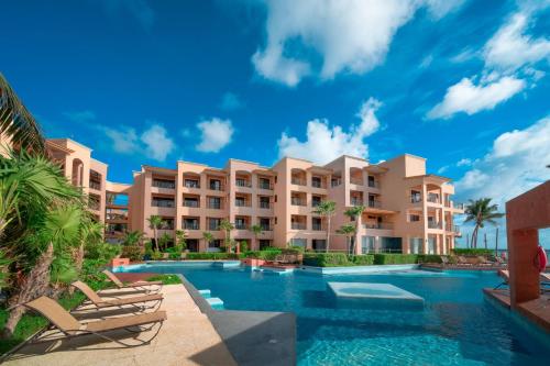 an image of a resort with a swimming pool at Condo Surf 301 - Luxury Oceanview Beachfront with Gym - At El Faro Condos in Playa del Carmen
