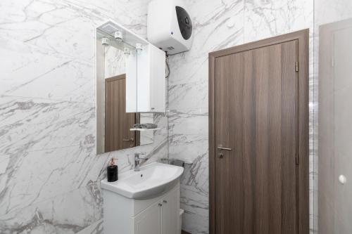 a white bathroom with a sink and a mirror at Villa Mare in Klek
