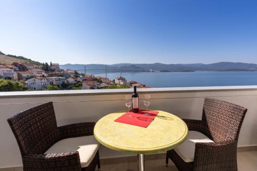 a table with a bottle of wine on a balcony at Villa Mare in Klek