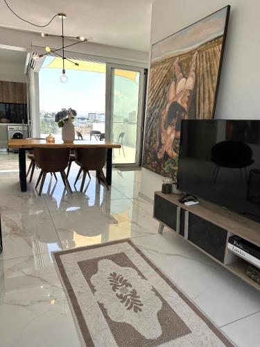 a living room with a table and a television at Luxury City Penthouse-Panoramic View-Near Unic in Nicosia