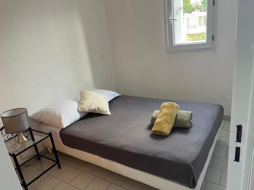 un lit avec deux oreillers dessus dans une chambre dans l'établissement T2 proche des plages, à Sète