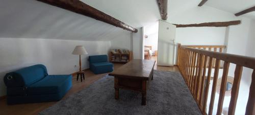 a living room with a blue chair and a table at Le Jas des Sagnières - Un Gite de Charme en Haute Provence in Sigoyer