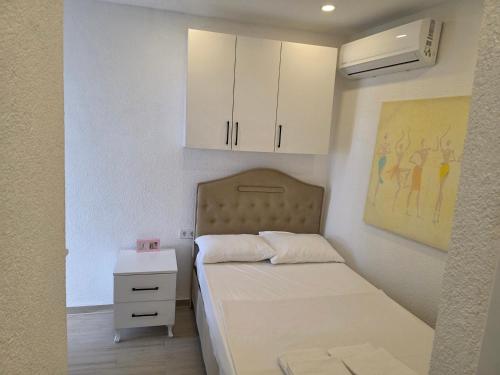 a small bedroom with a bed and white cabinets at Sevinc Akasya Luxury Villa in Milas