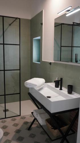 a bathroom with a white sink and a shower at B&B Casa Uliva in Castellaneta