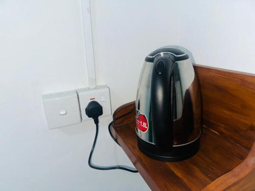 a black appliance is plugged into an electrical outlet at Jaya Residence - Near Airport in Negombo