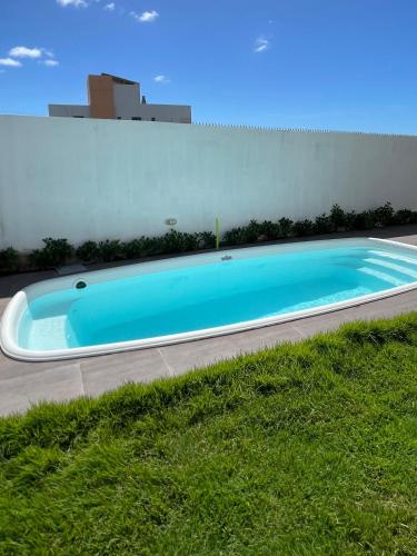 a large blue swimming pool next to a building at Casa Com Piscina em Jacumã e Carapibus in Jacumã