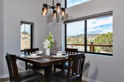 a dining room with a table and chairs and a window at Soak at Boulder Cove in Yucca Valley