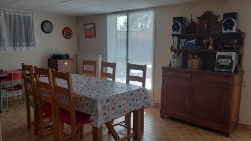 une cuisine avec une table et des chaises ainsi qu'une salle à manger dans l'établissement Réz de Jardin, à Saint-Martin-du-Mont