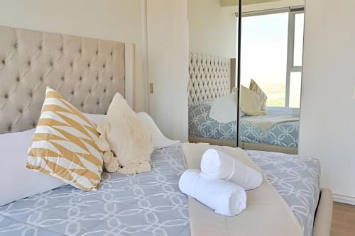 a bedroom with a bed with pillows and a mirror at Lobby 33 in Guadalajara
