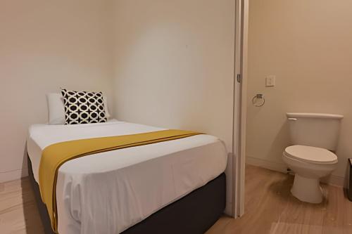 a small bedroom with a bed and a toilet at Lobby 33 in Guadalajara