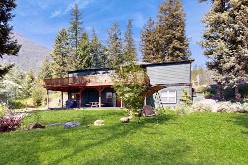 a house in the middle of a grassy yard with a building at Hungry Horse Hideout - Lower Level in Hungry Horse