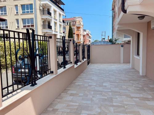 a balcony with a black fence and a sidewalk at Апартаменти Bella Deluxe in Ravda
