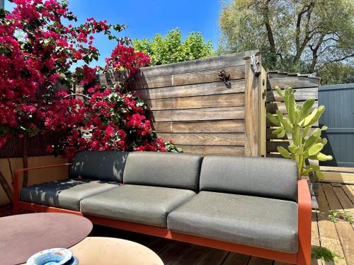 un canapé assis devant une clôture avec des fleurs dans l'établissement L'Ecrin, à La Ciotat