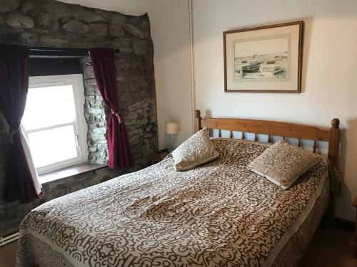 une chambre avec un lit et une fenêtre dans l'établissement Beach Cottage, à Little Haven