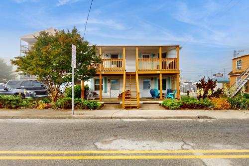 a yellow house with a deck on a street at Straney #3-Sea Renity in Ocean City