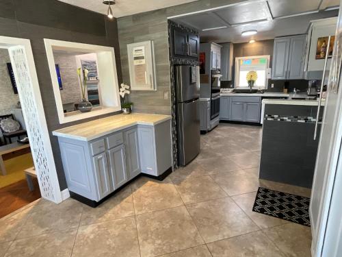 a kitchen with white cabinets and a black refrigerator at Spacious Ranch 7 min to beach/ airport Pet friend in Melbourne