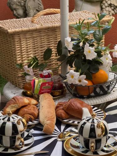 a table with bread and croissants and a basket of flowers at Villa Romana in Saint-Tropez