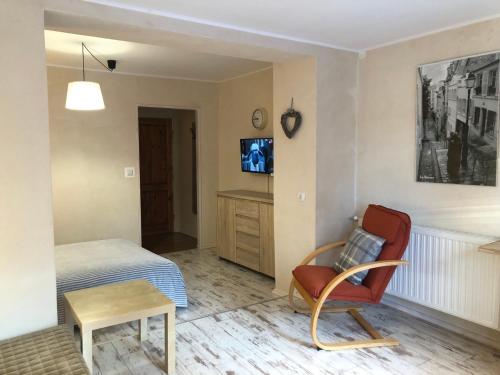 a bedroom with a bed and a chair and a tv at Willa Avita in Karpacz