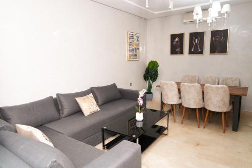 a living room with a couch and a table and chairs at Appartement de très haut Standing à la Marina de Saïdia Résidence TAMARIS 6 piscine VIP in Saidia 