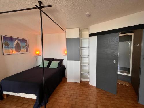 une chambre avec un lit à baldaquin dans une pièce dans l'établissement Evasion en Bord de Mer, au Barcarès