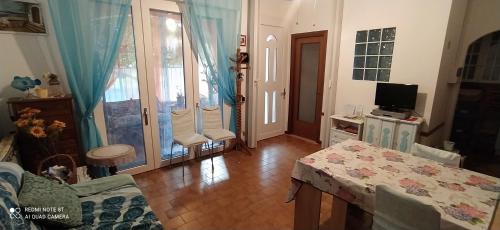 Una sala de estar con una mesa y un televisor. en La casa di nonna Lina al mare - senza barriere, en Torre del Lago Puccini