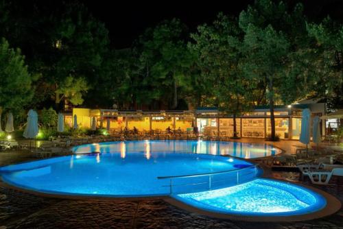 a large blue swimming pool at night at Excelsior Prince ApartHotel in Sunny Beach