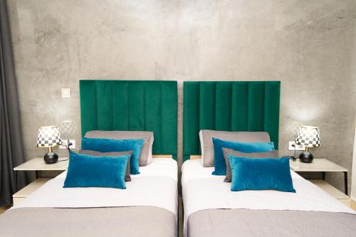 two beds with blue pillows in a room at Appartement de très haut Standing à la Marina de Saïdia Résidence TAMARIS 6 piscine VIP in Saidia 