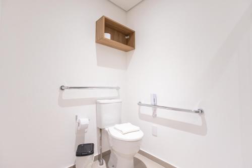 a white bathroom with a toilet and a sink at 360 VN Turiassú by Housi in Sao Paulo