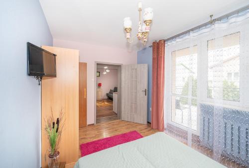 a bedroom with a bed and a large window at Noclegi Paradise in Darłówko