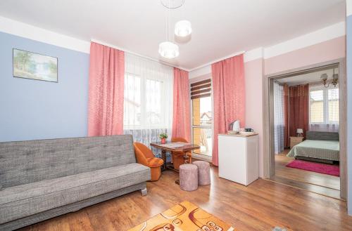 a living room with a couch and a bed at Noclegi Paradise in Darłówko