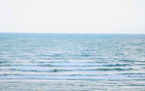 a large body of water with small waves at Homestay The Sunset in Phan Thiet