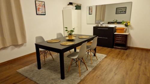 a dining room table with chairs and a kitchen at Guest House da Mata2 in Póvoa de Varzim
