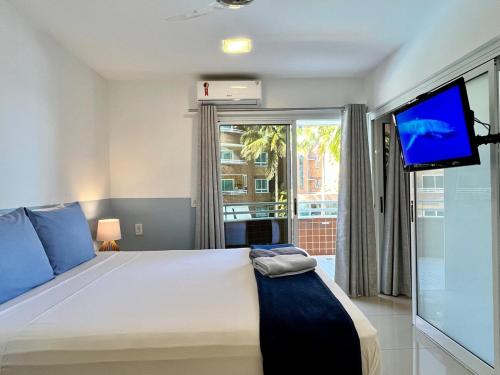 a bedroom with a large bed and a flat screen tv at Ocean View - Camboinhas Beach I 214B in Niterói