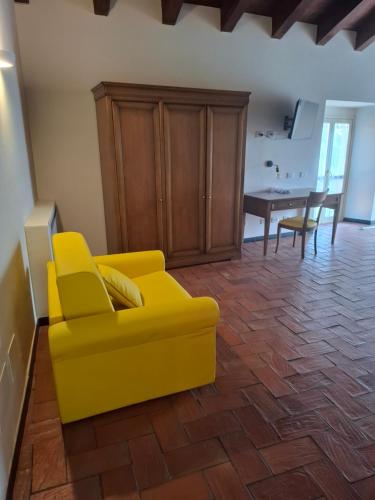 a yellow couch in a living room with a table at Albergo Palazzo Costa in Beverino