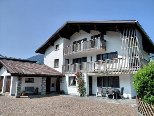 a white building with a balcony and a patio at Ferienhaus Gioia in Schruns-Tschagguns