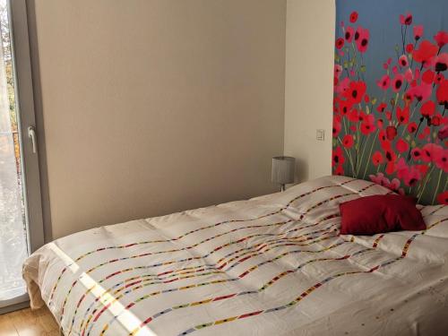 - un lit dans une chambre ornée d'une peinture florale sur le mur dans l'établissement La gemmeuse, à Aureilhan