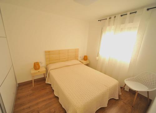 a small bedroom with a bed and a window at LA CURVA Orange Costa in Benicàssim