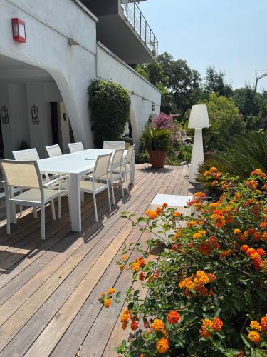 a table and chairs on a wooden deck with flowers at Villa Hirondelles 35 in Cavalaire-sur-Mer