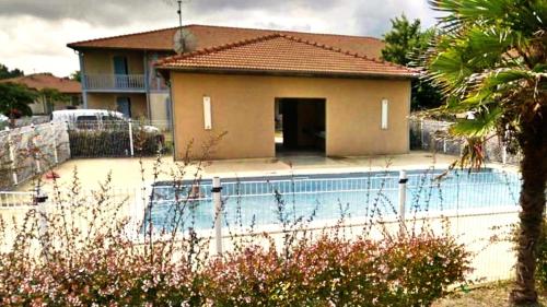 une maison avec une piscine devant une maison dans l'établissement La gemmeuse, à Aureilhan