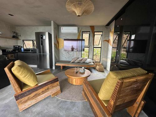 a living room with chairs and a tv in a trailer at Bangalo do Sol in CÃ¡ssia