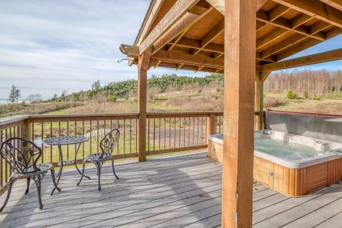 a deck with a hot tub and a table and chairs at Netarts Coastal Retreat - Meredith Lodging in Tillamook