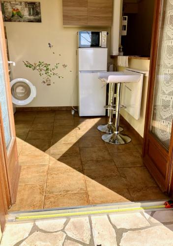 a small kitchen with a refrigerator and a toilet at Windmill Cottage of Monpazier in Capdrot