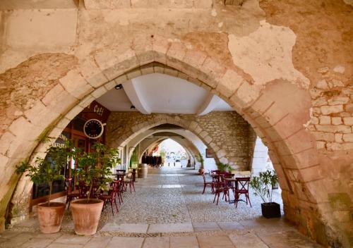 an archway in a building with tables and chairs at Windmill Cottage of Monpazier in Capdrot