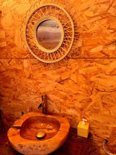 La salle de bains est pourvue de toilettes en bois et d'un miroir. dans l'établissement la Bulle de cocagne, à Six-Fours-les-Plages