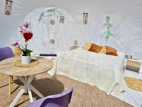 une chambre blanche avec un lit et une table dans l'établissement la Bulle de cocagne, à Six-Fours-les-Plages