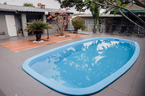 a large blue swimming pool in a yard at Pousada Marias Foz - Centro in Foz do Iguaçu