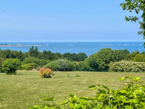 a field with the ocean in the background at Gîte de charme in Paimpol