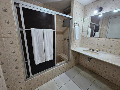 a bathroom with a sink and a mirror and towels at ABC Apart Hotel in Brasilia