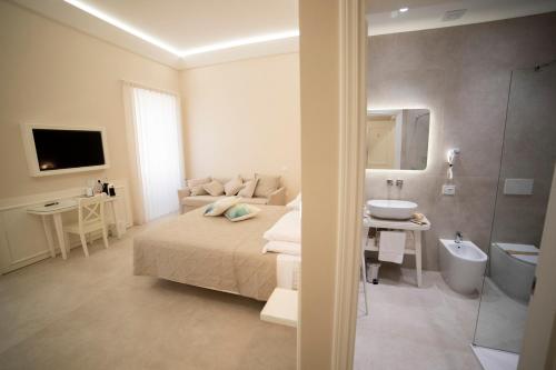 a bedroom with a bed and a bathroom with a sink at 5 lune Tropea in Tropea